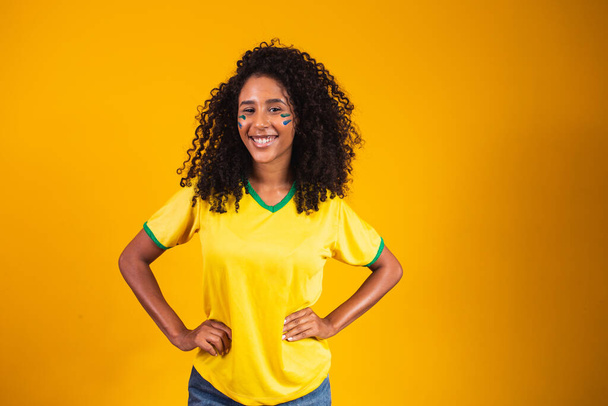 Brazilian supporter. Brazilian woman fan celebrating on soccer or football match on yellow background. Brazil colors. - Zdjęcie, obraz