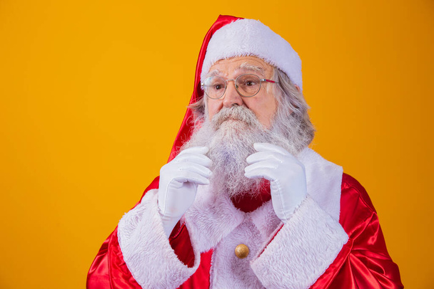 Santa Claus touching his long white beard. - Фото, изображение