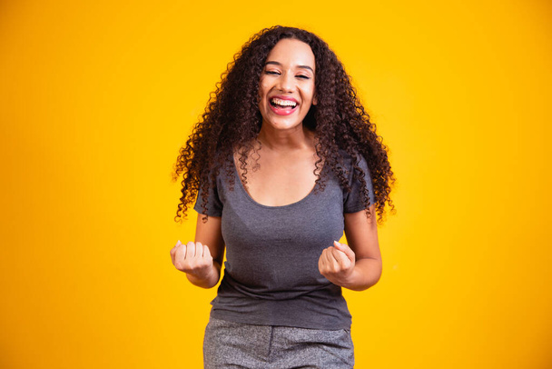 Portrait of happy beautiful young afro woman with perfect smile raised her hands up and celebrate achievement goal. - Fotoğraf, Görsel