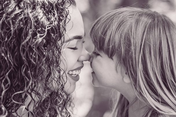 mother and daughter giving Eskimo kiss. Mothers Day. Afro mother and white daughter - Foto, Imagem