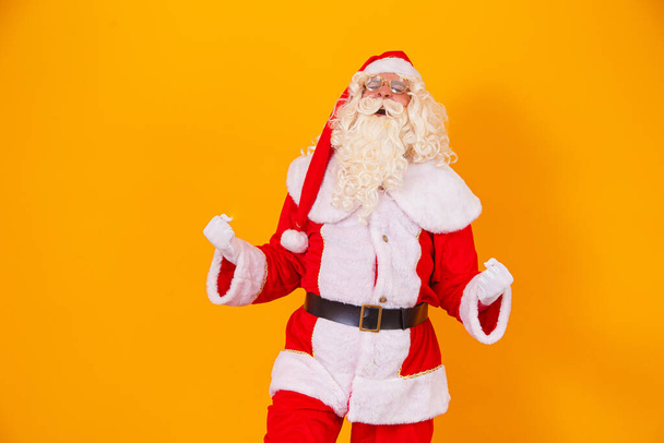 Santa Claus celebrating victory in yellow background - Photo, Image