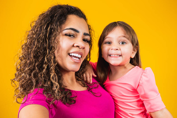 Happy Mothers Day! Adorable caucasian child with his mother making selfie on yellow background. - Foto, immagini