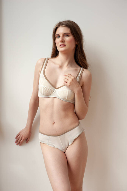 beautiful woman posing in underwear in studio, beige background  - Fotografie, Obrázek