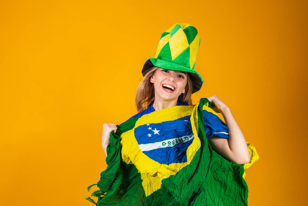 Blonde Brazilian fan celebrates in yellow background. Yes! - Fotó, kép