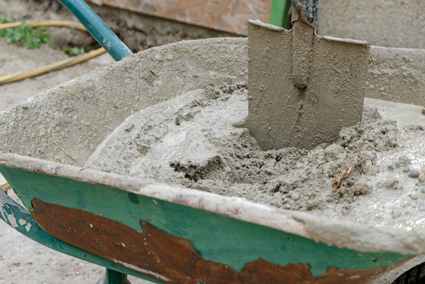 Cemento, pala, carretilla. Mezclar el cemento a mano. Pasos. - Foto, Imagen