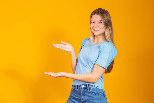 Image of a happy positive young girl isolated over yellow wall background - Foto, imagen