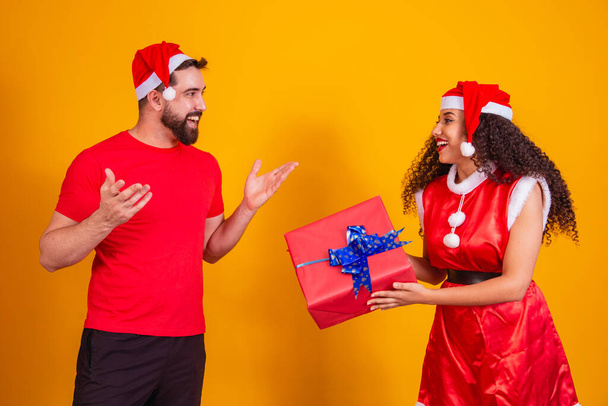 Una joven pareja de amantes intercambiando regalos en Navidad. Feliz Navidad. - Foto, imagen