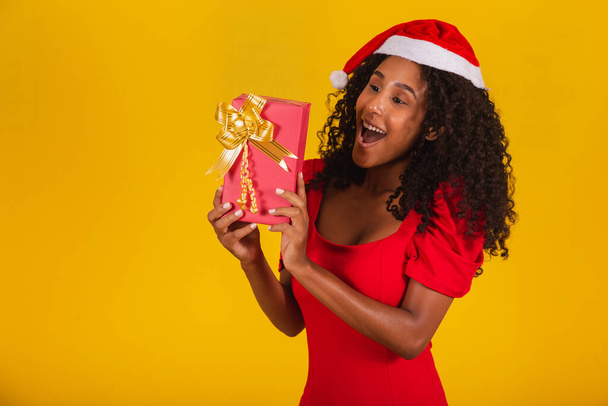 Happy excited young woman in Santa hat with gift box. - Foto, Imagen