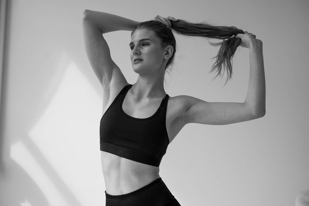 jovem mulher em roupas esportivas fazendo exercícios na sala - Foto, Imagem