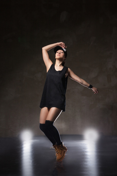 Sexy young woman in a trendy clothes over black background - Fotó, kép