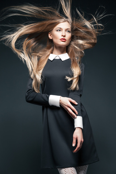 Closeup portrait of blond model posing with hair fluttering in the wind - Foto, afbeelding
