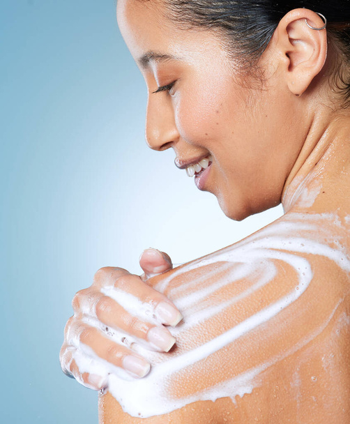 Дайте моїй шкірі любов, яку вона заслуговує. приваблива молода жінка, використовуючи миття тіла, приймаючи душ на синьому фоні
 - Фото, зображення