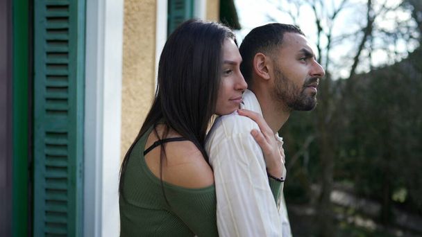 Girlfriend embracing boyfriend from behind while standing outside at home balcony. A loving Middle Eastern couple showing love and support while contemplating nature - Photo, Image