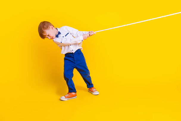 Full length photo of little schoolkid pull rope heavy contest in school isolated on shine color background. - Фото, зображення