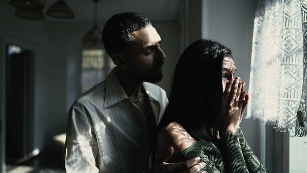Egy gondoskodó arab barát vigasztalja könnyes barátnőjét az ablaknál egy nehéz pillanatban, támogatást és empátiát mutatva. - Fotó, kép