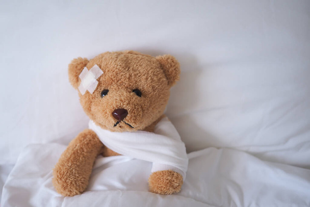 bear with bandage, child medical care . injured child teddy bear and painful in hospital, fell ill in the bed, accident, insurance, health care, risk, loss, emergency, protection, treat, kid , bab - Photo, Image