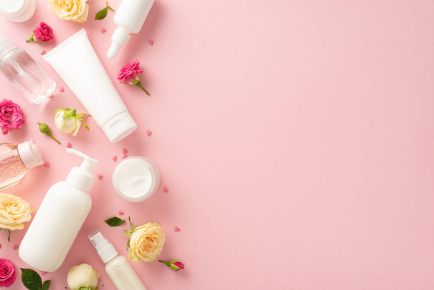 A gorgeous display of natural tender skincare concept with top view flat lay pump bottles, pipettes cream bottles lovely roses on a pastel pink background. The empty space is the perfect for brandingA gorgeous display of natural tender skincare conce - Photo, Image