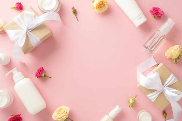 Luxurious natural skincare concept. Top view flat lay of exquisite pump bottle, delicate pipette, gifts, cream jars and tubes with rose petals on pastel pink background with empty space - Photo, Image