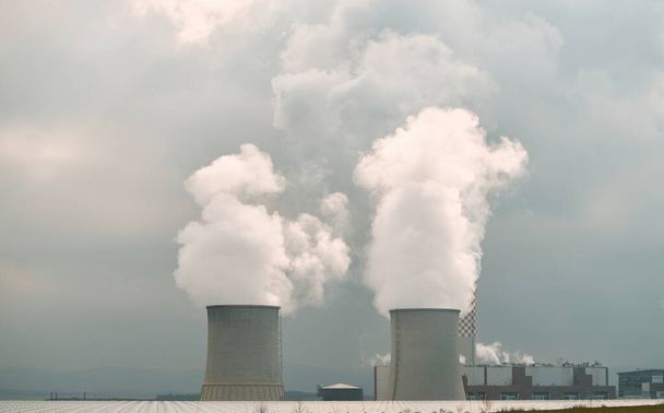 Two large concrete cooling towers with smoke coming out of them. Coal power plant. - Photo, Image