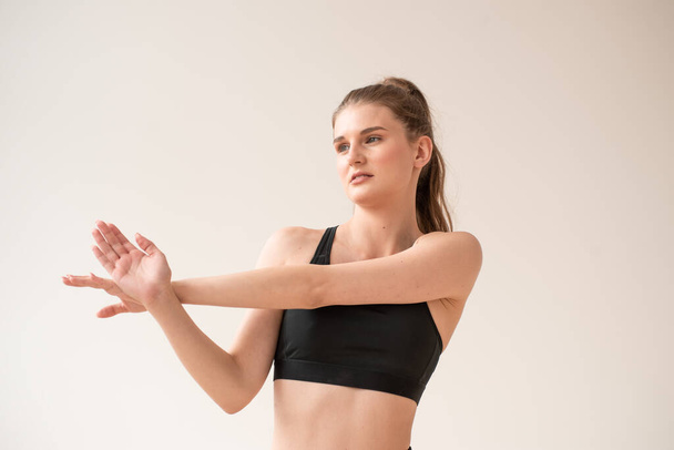 jovem bela mulher em sportswear fazendo exercícios de ioga no fundo branco - Foto, Imagem