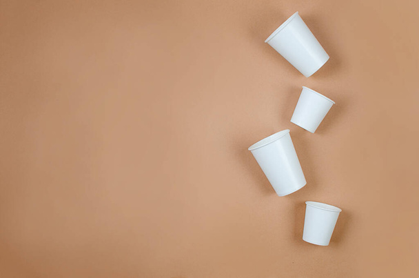 Top view on white paper cups on beige background. Kraft paper food packaging. Street food paper packaging from natural material. rejection of plastic.  free from plastic,  - Foto, Imagen