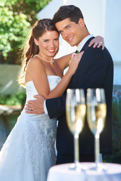 Que comience la recepción. Retrato de jóvenes recién casados felices con copas de champán en primer plano - Foto, Imagen