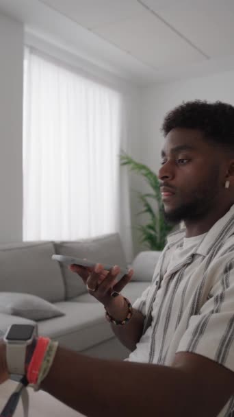 Μαύρος νεαρός άνδρας που στέλνει φωνητικό μήνυμα μετά την περιήγηση στο τηλέφωνο - Πλάνα, βίντεο