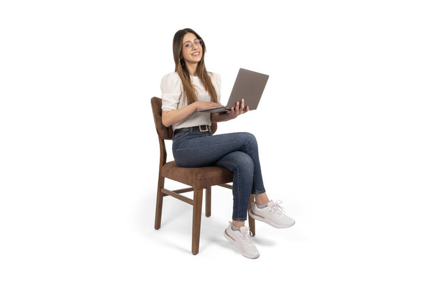 Cheerful woman using laptop, full body shot cheerful woman using laptop. Beautiful attractive young 20s girl wearing casual working on notebook. Looking camera, isolated white background. Copy space. - Фото, зображення