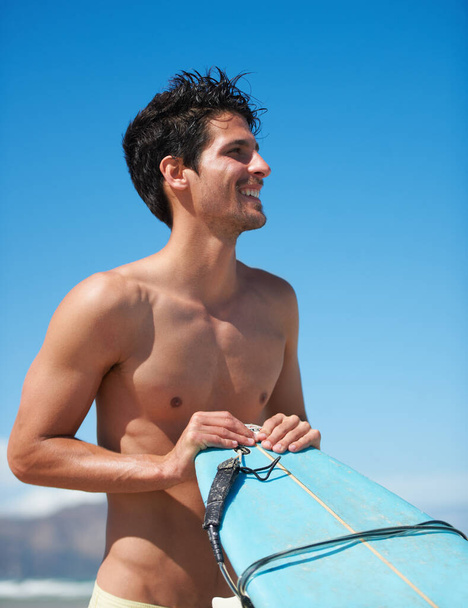 The waves are calling. An attractive young man getting ready to hit the waves - Zdjęcie, obraz