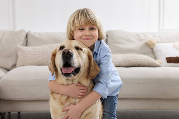 Cute little child with Golden Retriever at home. Adorable pet - Photo, Image
