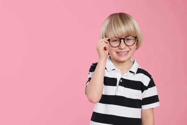 Cute little boy wearing glasses on pink background, space for text - Fotografie, Obrázek
