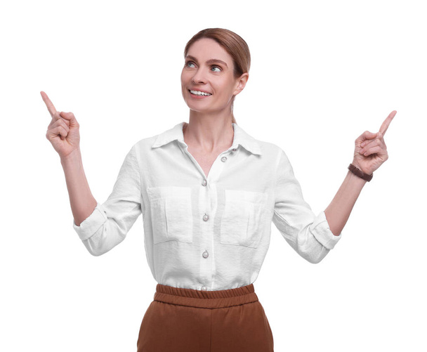 Beautiful happy businesswoman pointing at something on white background - Fotó, kép