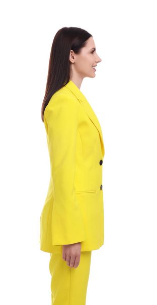 Businesswoman in yellow suit standing on white background - 写真・画像