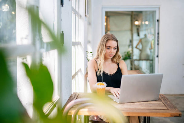 Uma mulher, Freelance, a usar um portátil sentado à mesa. conceito freelance. - Foto, Imagem