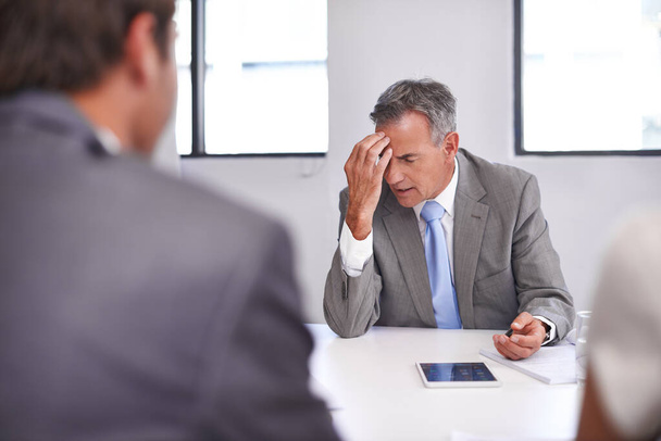 Faire face à des affaires qui ont mal tourné. un homme d'affaires mature regardant mécontent dans une réunion avec ses employés - Photo, image