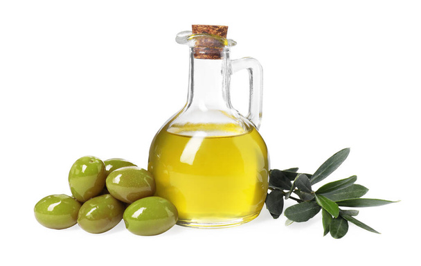 Glass jug of cooking oil, ripe olives and green leaves isolated on white - Foto, Imagem