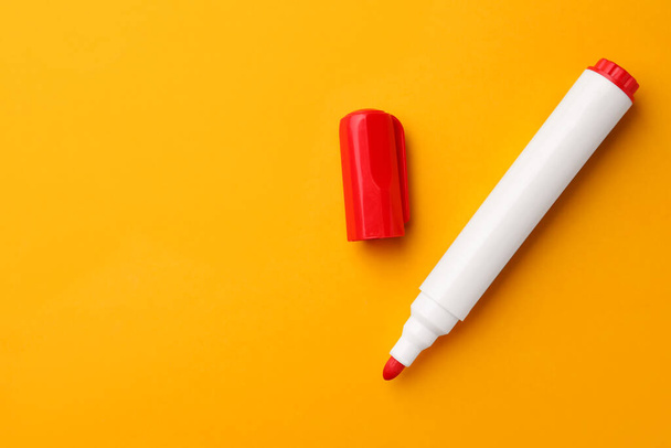 Bright red marker on orange background, flat lay. Space for text - Fotoğraf, Görsel