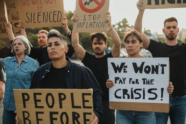 Gruppe entschlossener Kämpfer für Ökologie hält Plakate mit Slogans in die Höhe und trifft sich während des Streiks auf der Straße - Foto, Bild
