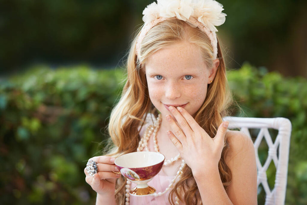 Veel plezier op het theekransje. Een schattig klein meisje met een thee feestje buiten - Foto, afbeelding