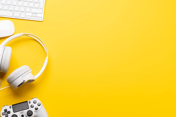 黄色の背景にゲーム機器や技術アクセサリーは、ゲームや技術関連のテーマに最適です。コピースペース付きフラットレイアウト - 写真・画像