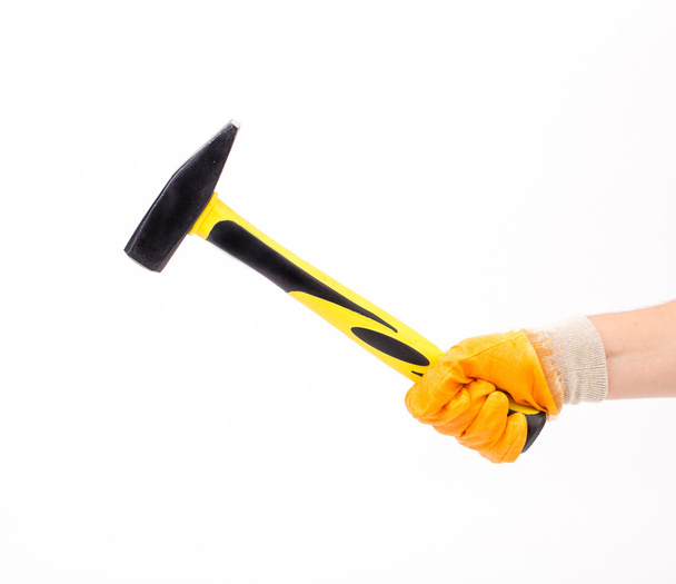 Hand with glove holding a hammer - Foto, imagen