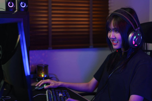 Mujer ciber hacker gamer en auriculares cara seria para jugar juegos o piratear el sistema de programación. - Foto, imagen