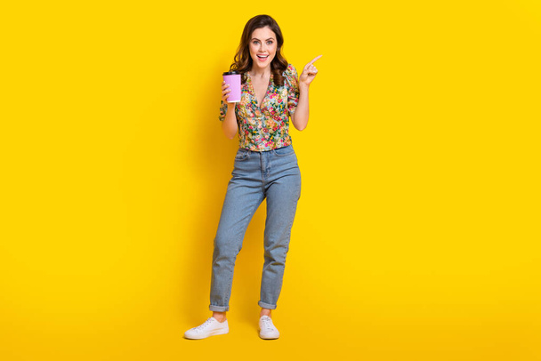Full body photo of young woman wear shirt hold her favorite espresso coffee point finger favorite cafeteria isolated on yellow background. - Фото, изображение