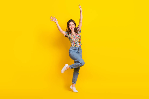 Full length photo of cheerful pretty woman dressed vintage flower print blouse dancing rising arms isolated yellow color background. - Foto, imagen