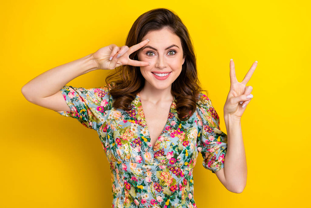 Portrait of pretty nice lady arms fingers demonstrate v-sign near eye isolated on yellow color background. - Фото, зображення