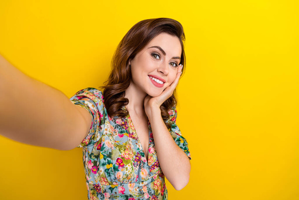 Photo of dreamy cute lady wear retro flower print blouse arm cheek recording video vlog isolated yellow color background. - Fotó, kép
