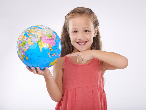 Lets give our children the world. A cute little girl holding a globe isolated on white - Photo, Image