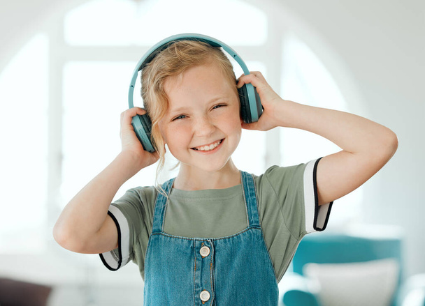 Słucham mojej ulubionej piosenki. urocza dziewczynka stojąca sama w domu i słuchająca muzyki przez słuchawki - Zdjęcie, obraz