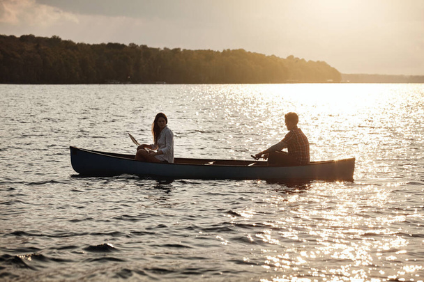 Just the two of us on the lake today. a young couple rowing a boat out on the lake - Photo, Image