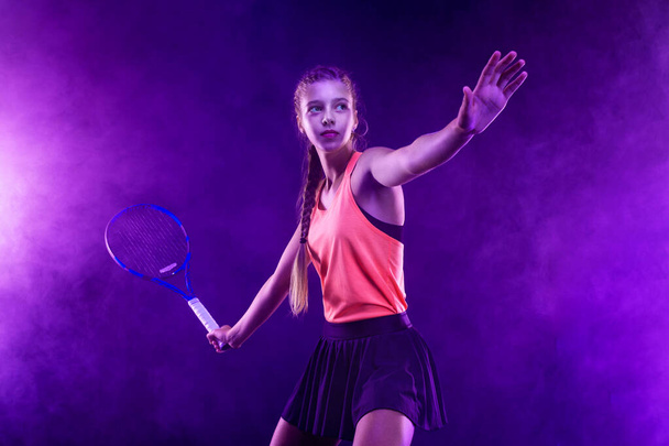 Tennis player. Beautiful girl teenager and athlete with racket in pink sporswear and hat on tennis court. Fashion and sport concepts - Foto, imagen